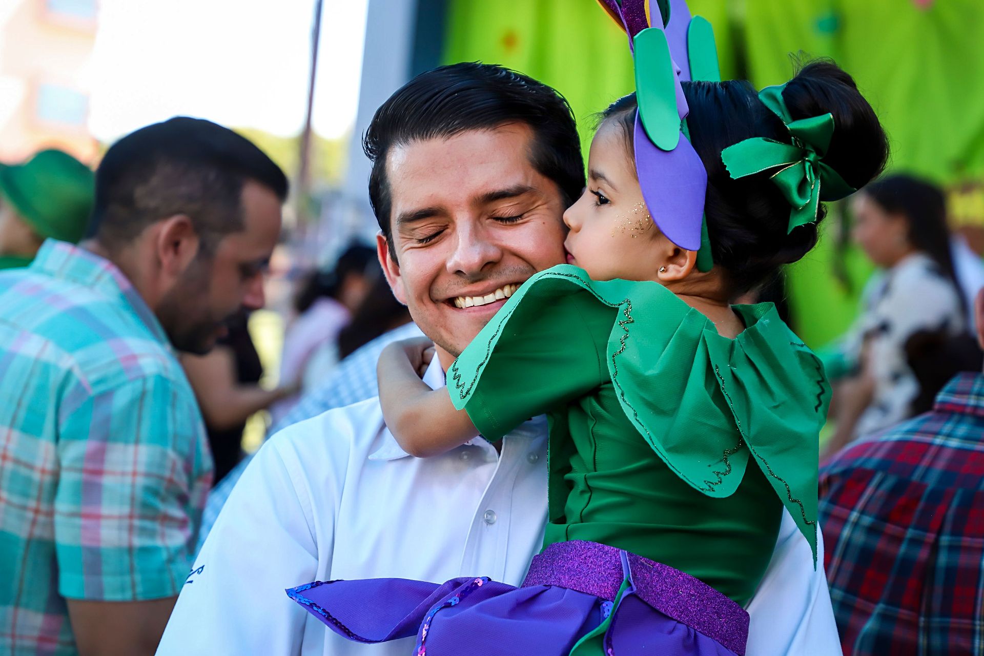 Alumna de Kínder con disfraz le da un beso a su papá durante un festival del colegio
